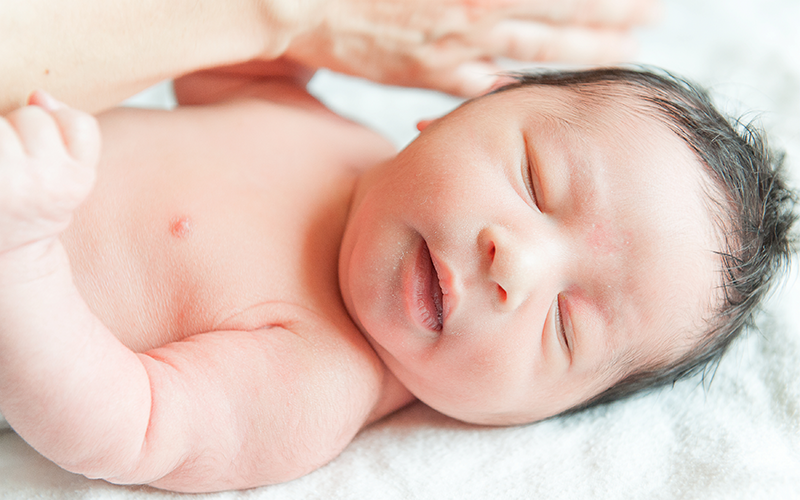 Un nouveau né à la maternité du CHU de Rouen photographié lors d'un atelier de massage bébé.