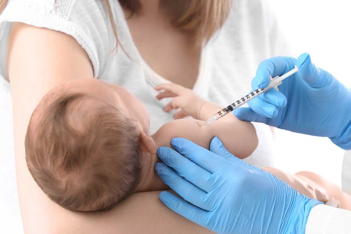 Un bébé dans les bras de sa mère se fait vacciner