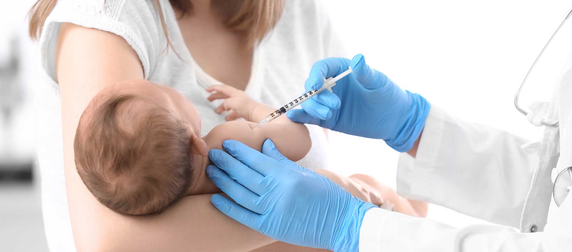 Un bébé dans les bras de sa mère se fait vacciner